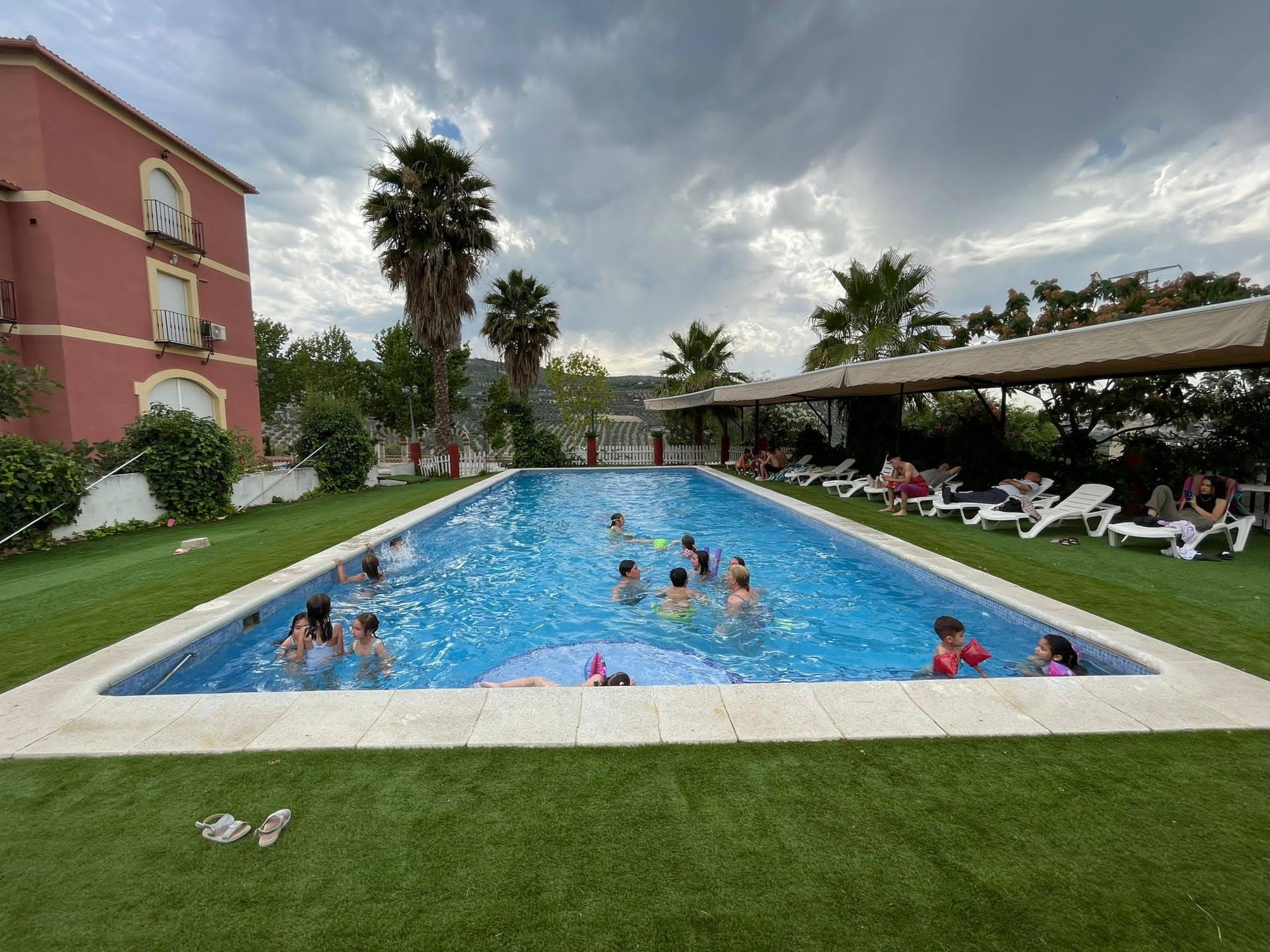 Familias disfrutando de la piscina del complejo